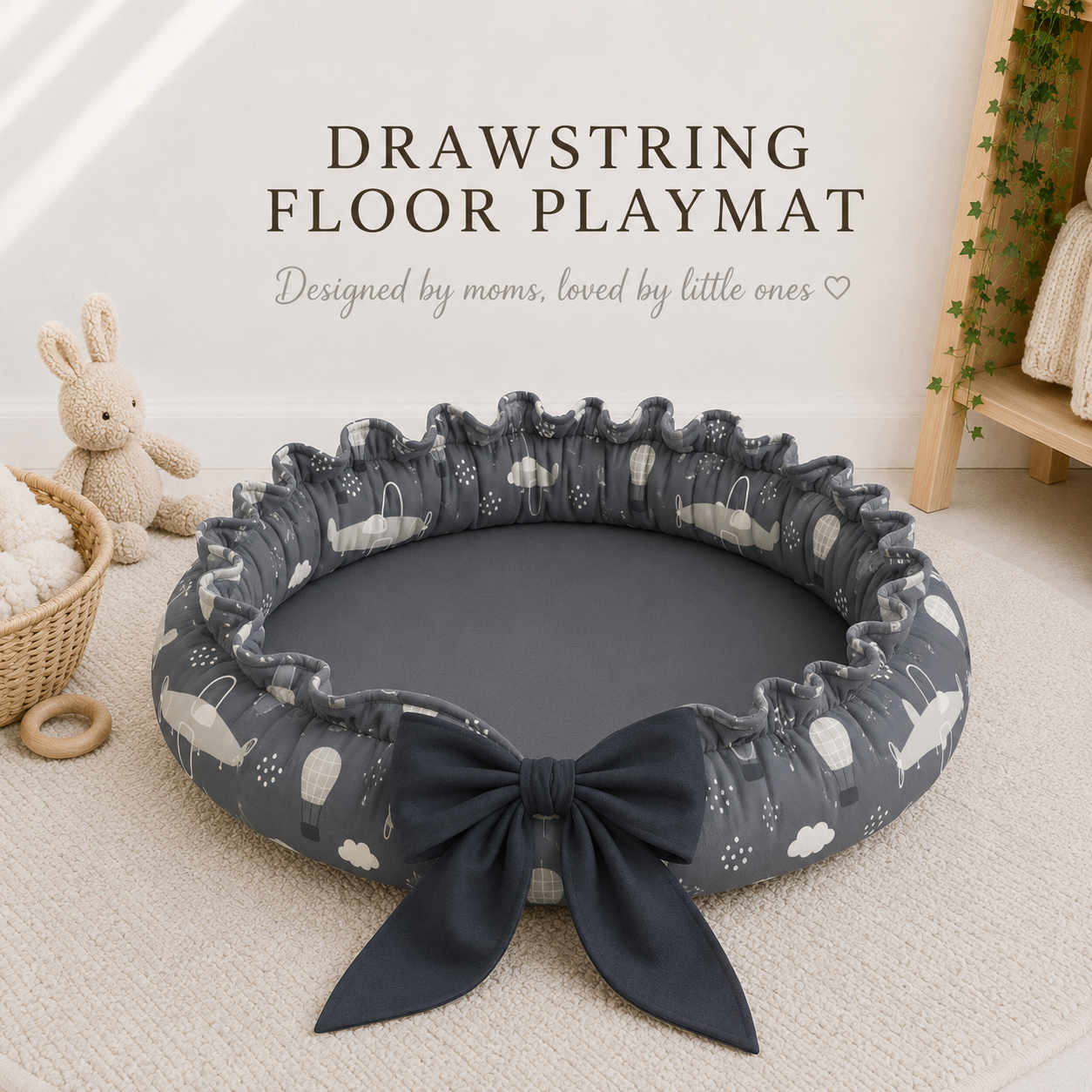Drawstring floor playmat with a plane pattern and bow on a light wooden floor.