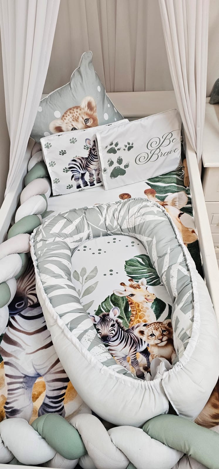 Children's room with a canopy bed, pillows, and a chair with animal-themed cushions.