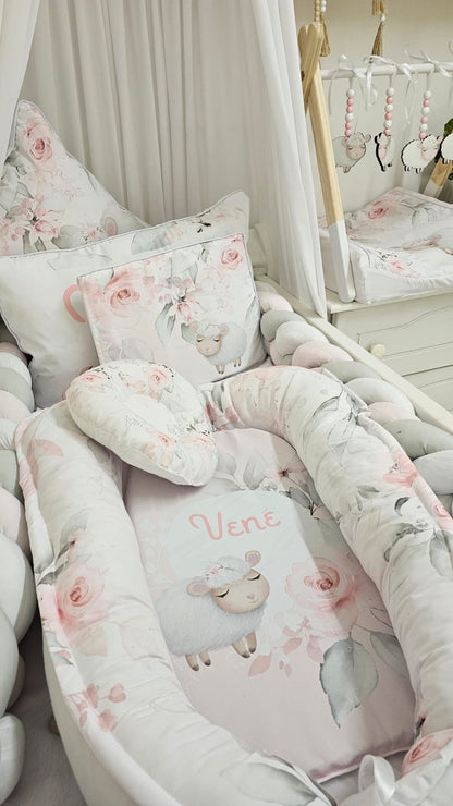 Crib with floral and animal-patterned bedding in a nursery setting.