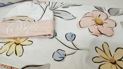 Floral patterned fabric with a folded piece of fabric displaying text.