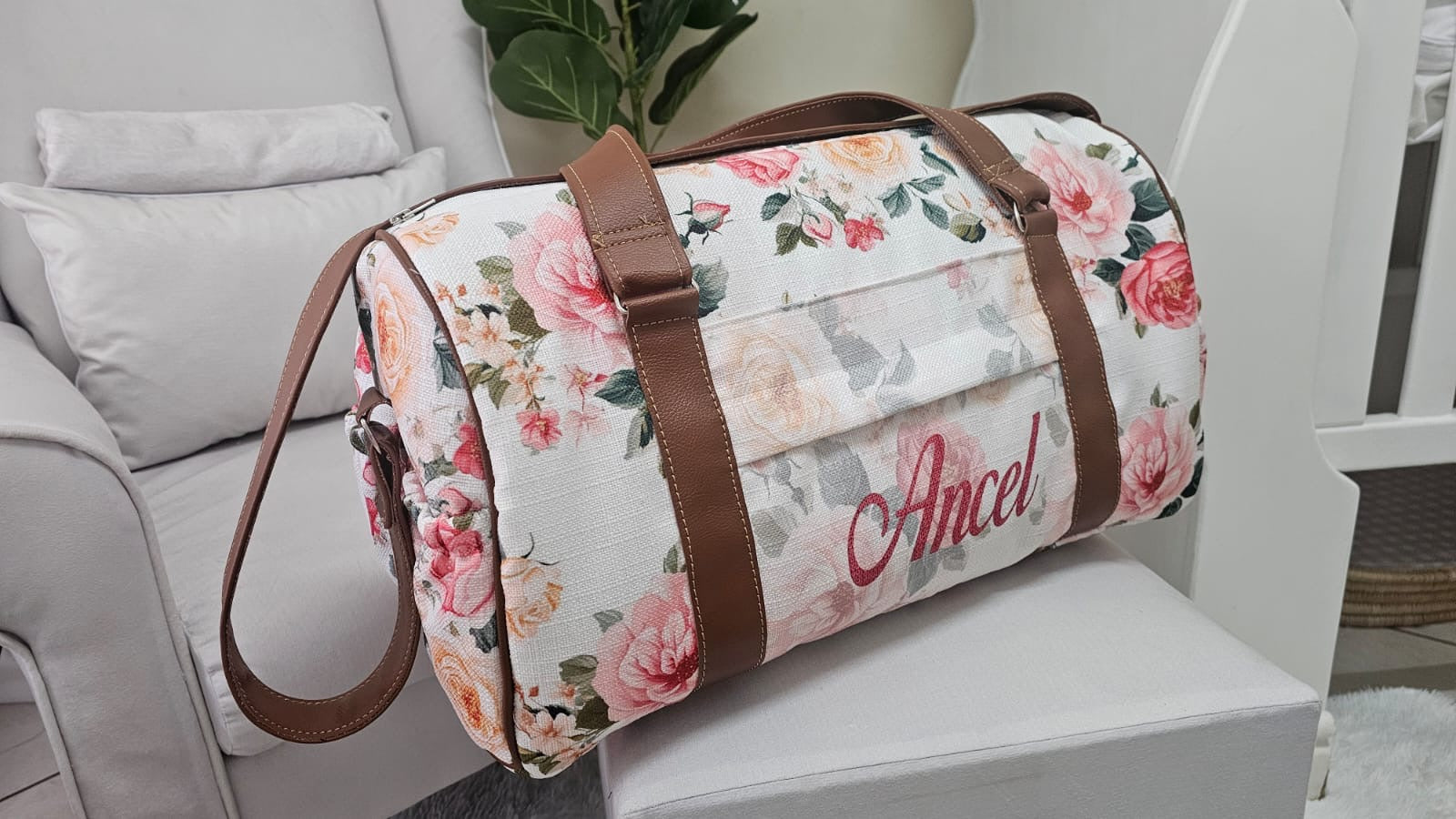 Floral-patterned duffel bag with 'Ancel' branding on a white surface.