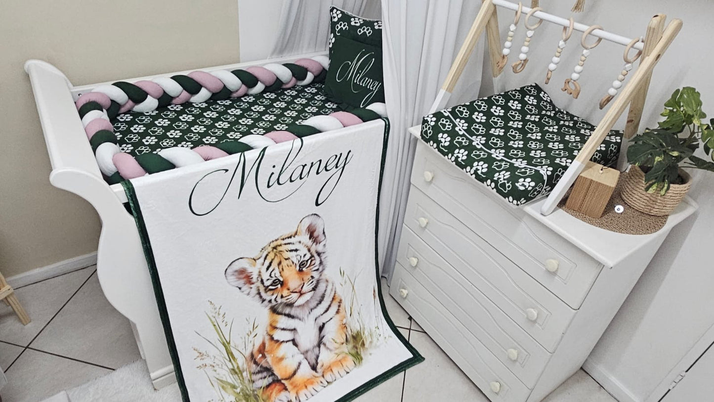 Crib with a blanket featuring a tiger design and the name 'Milaney'.