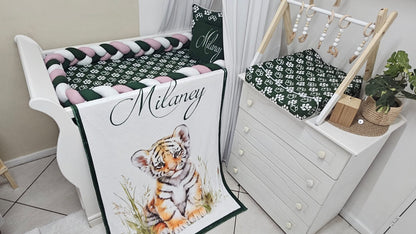 Crib with a blanket featuring a tiger design and the name 'Milaney'.