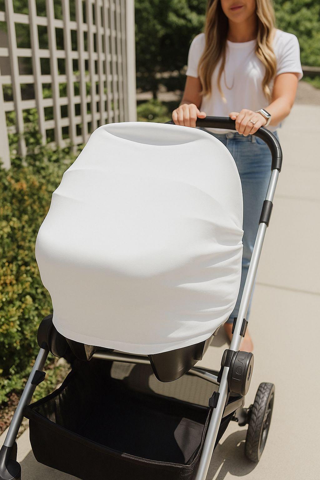 Person pushing a stroller with a white custom car chair cover on a sidewalk.