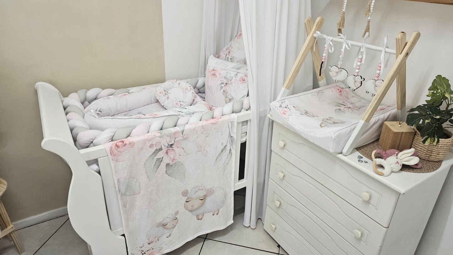 Nursery room with white crib, dresser, and decorative elements.