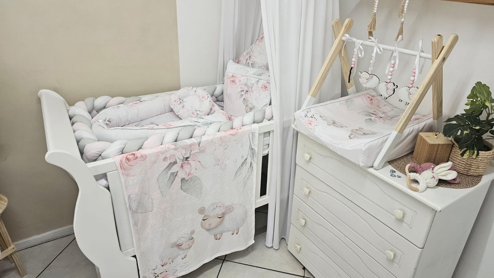 Nursery room with white crib, dresser, and decorative elements.