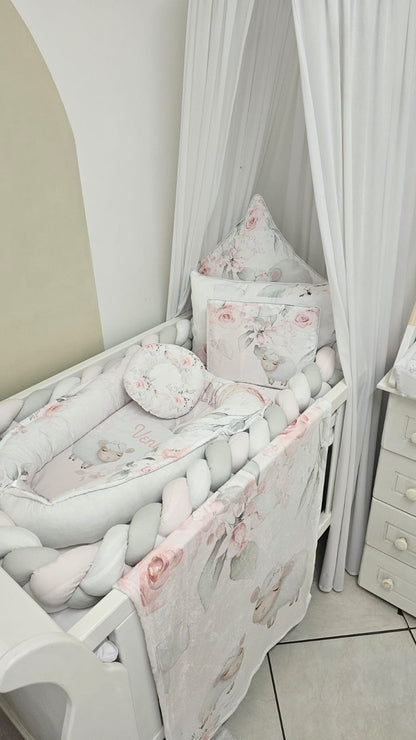 Baby crib with floral bedding and pillows in a room setting.