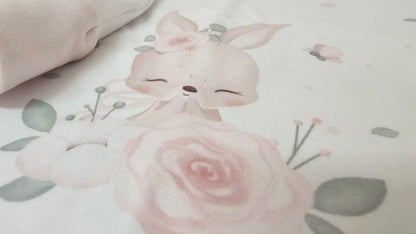 Cute cartoon bunny with a bow surrounded by pink roses and green leaves on a light background