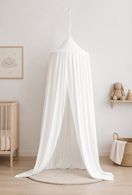 White canopy over a crib in a room with a wooden shelf and toys.