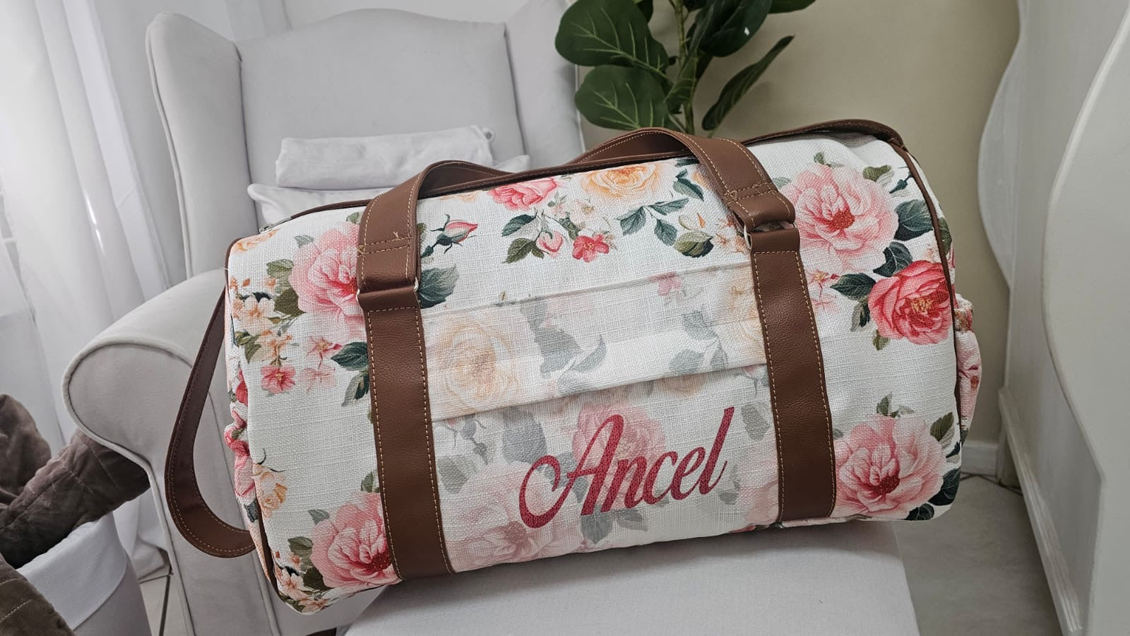Floral-patterned duffel bag with 'Ancel' branding on a white surface.