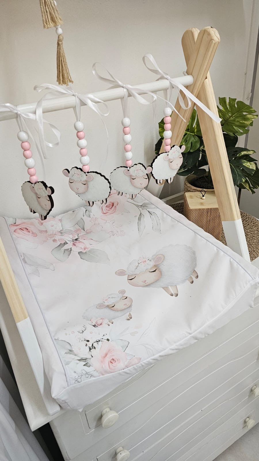 Crib with floral bedding and cloud-shaped toys in a nursery setting.