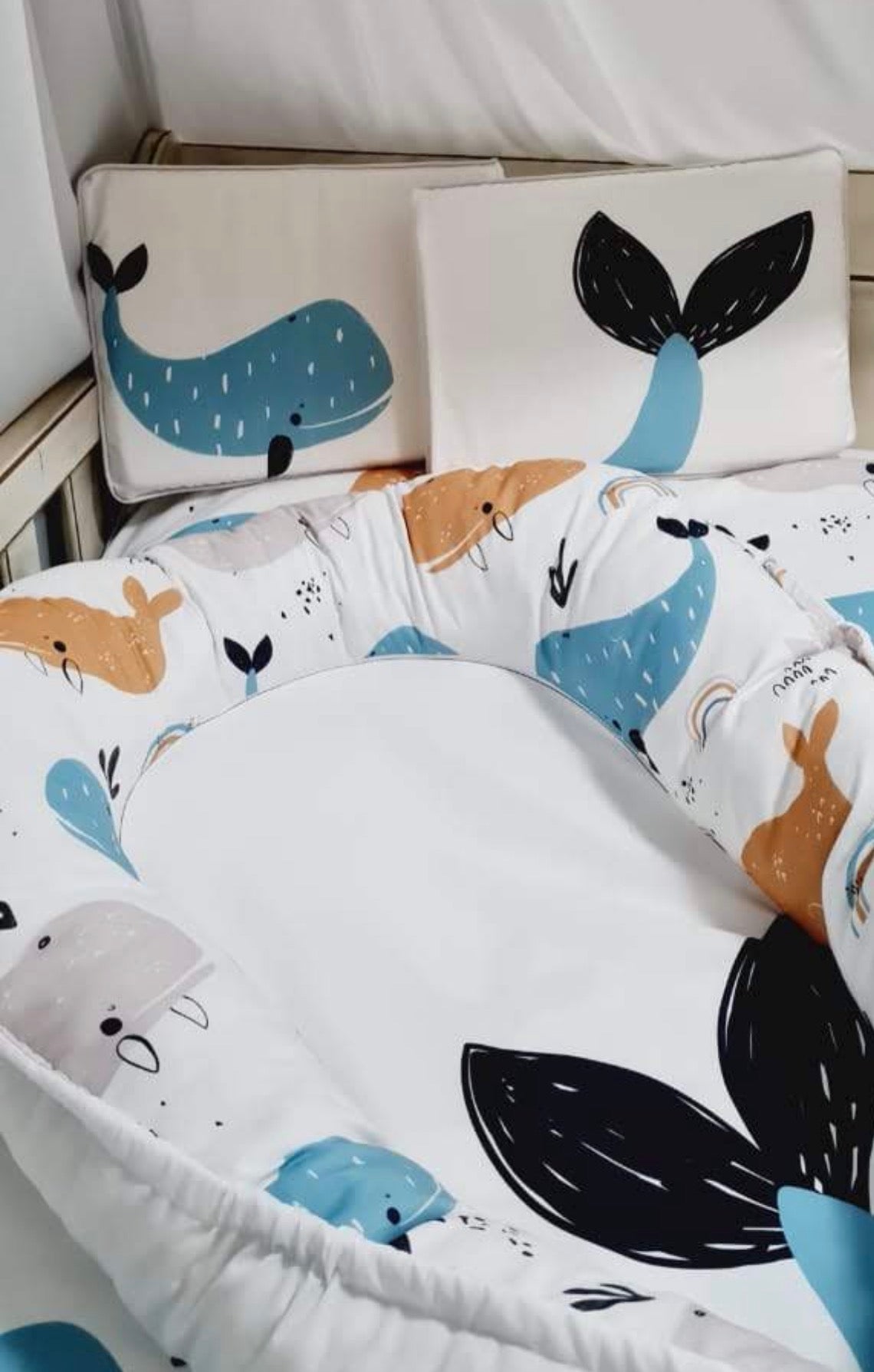Children's bedding set with whale patterns on a crib