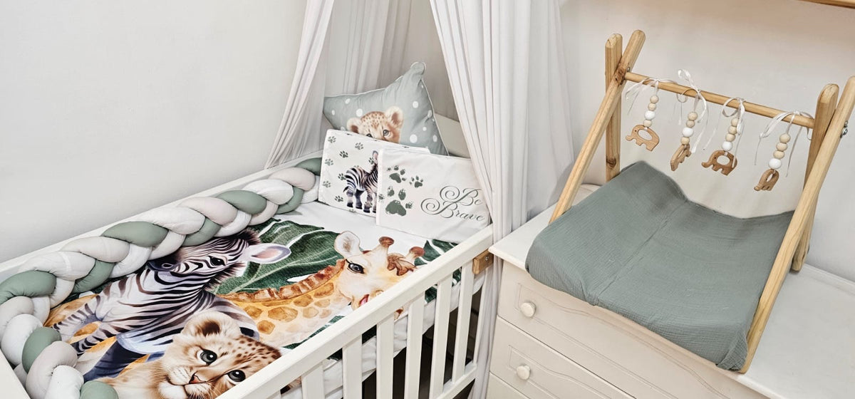 Children's crib with zebra print bedding and wooden crib mobile in a nursery.
