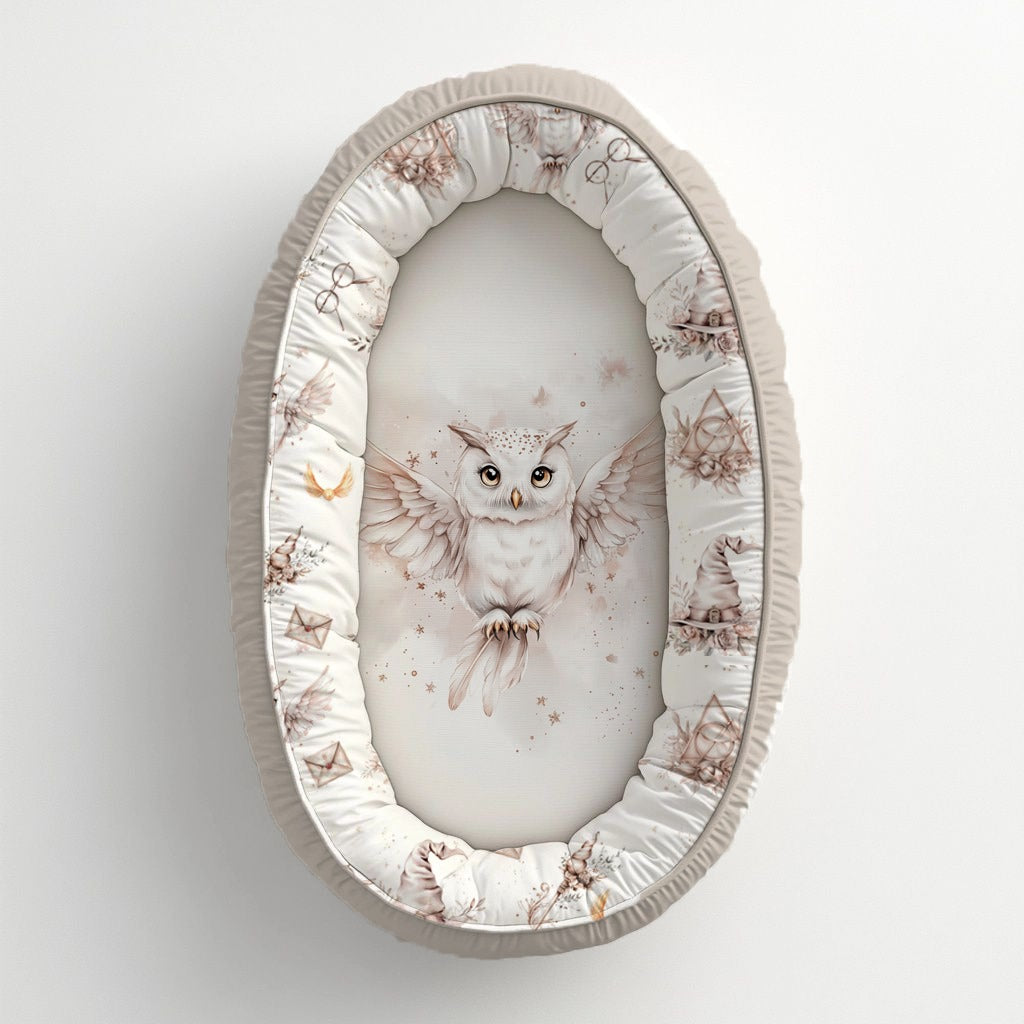 Blush Harry Potter baby nest featuring a magical white owl with soft blush wizard-inspired details, stars and delicate neutral illustrations | Blush Harry Potter babanes met ’n magiese wit uil, sagte ligpienk towenaar-geïnspireerde detail, sterretjies en delikate neutrale illustrasies.