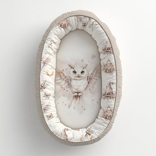 Blush Harry Potter baby nest featuring a magical white owl with soft blush wizard-inspired details, stars and delicate neutral illustrations | Blush Harry Potter babanes met ’n magiese wit uil, sagte ligpienk towenaar-geïnspireerde detail, sterretjies en delikate neutrale illustrasies.