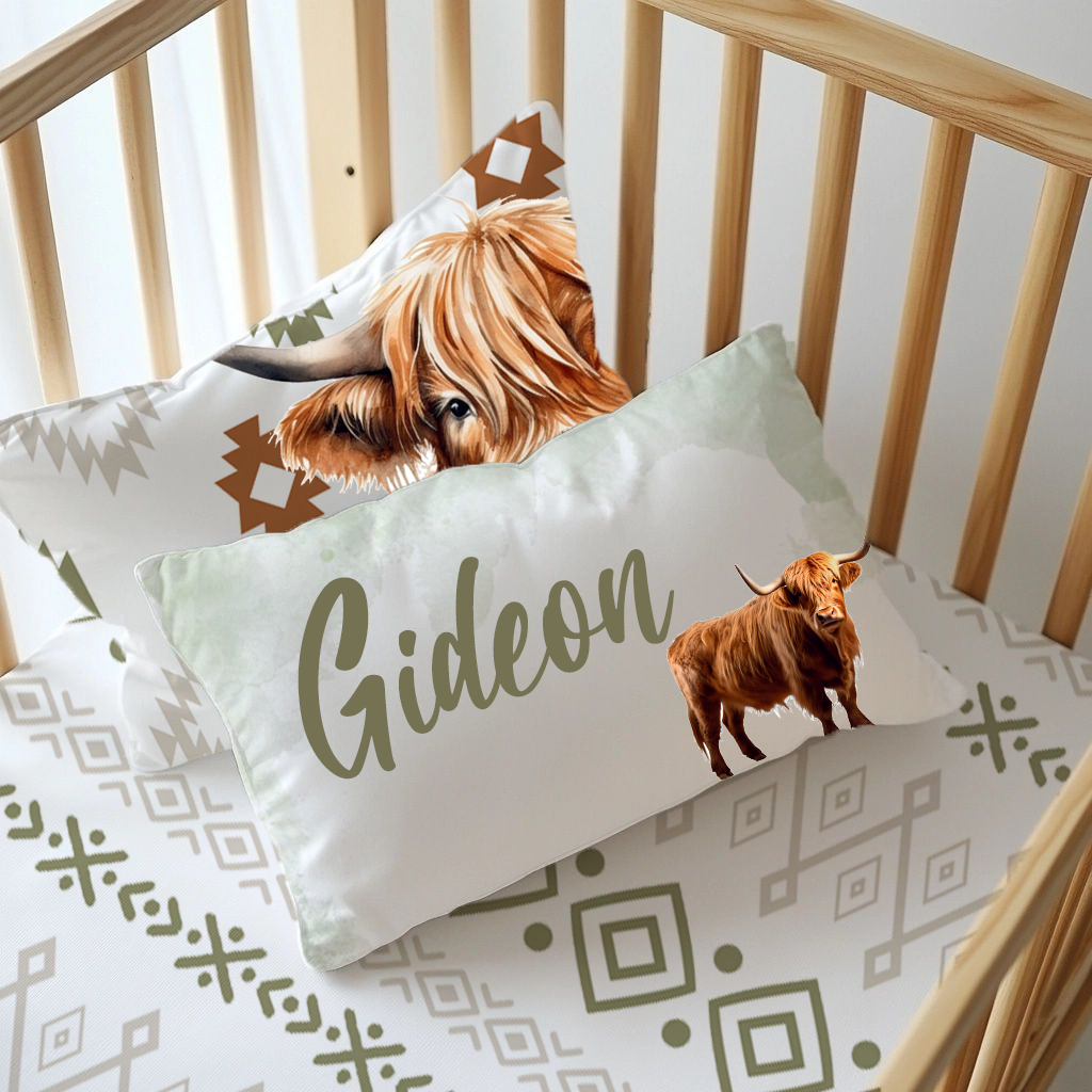 Boho Highlands Cow personalised nursery pillow featuring a Highland cow, soft sage and neutral boho patterns, and the name “Gideon” in large olive green script | Boho Highlands-bees gepersonaliseerde kinderkamer-kussing met ’n Highland-bees, sagte saliegroen en neutrale boho-patrone, en die naam “Gideon” in groot olyfgroen skrif.