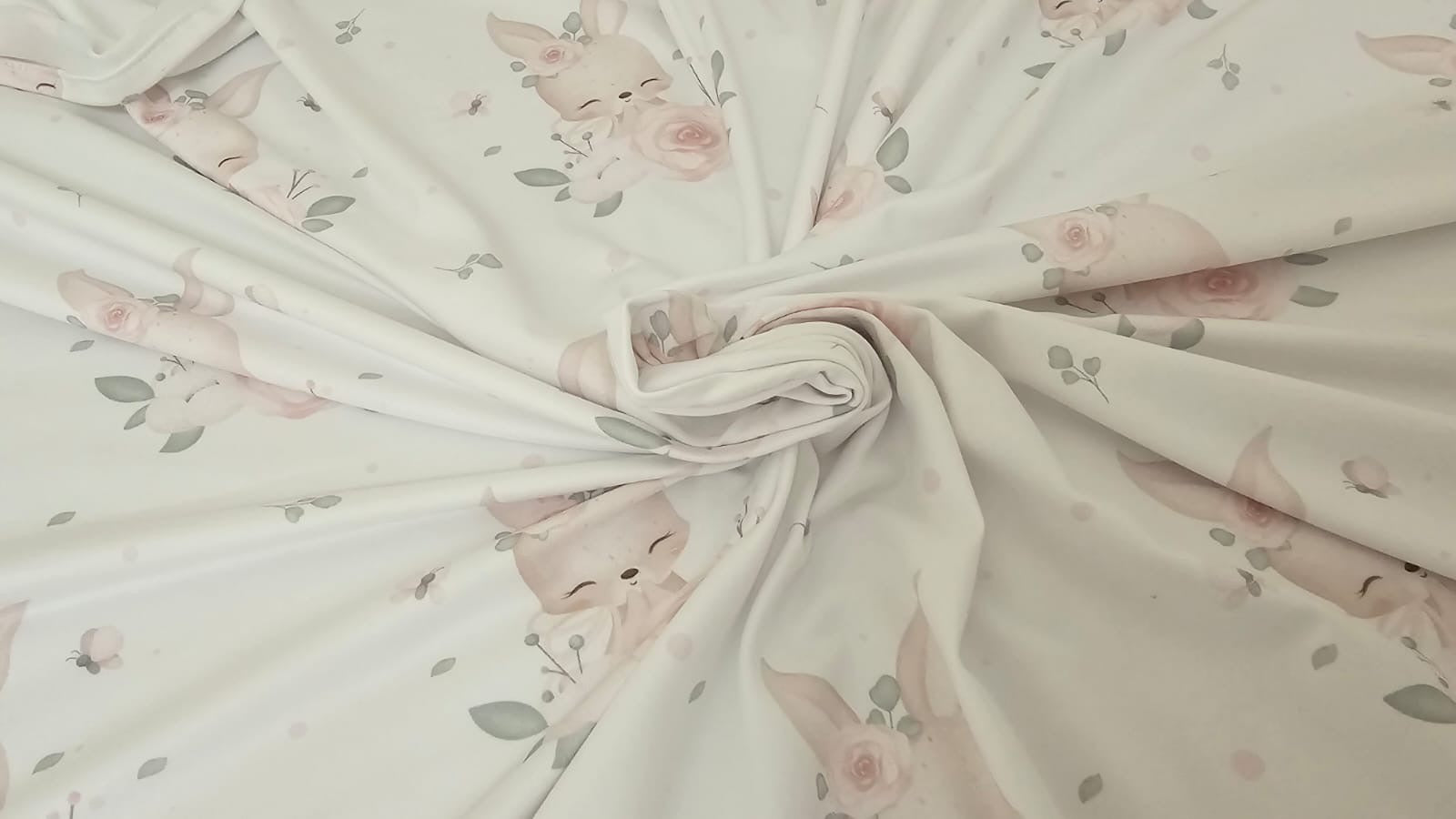Fabric with pink floral and bunny pattern on a light background