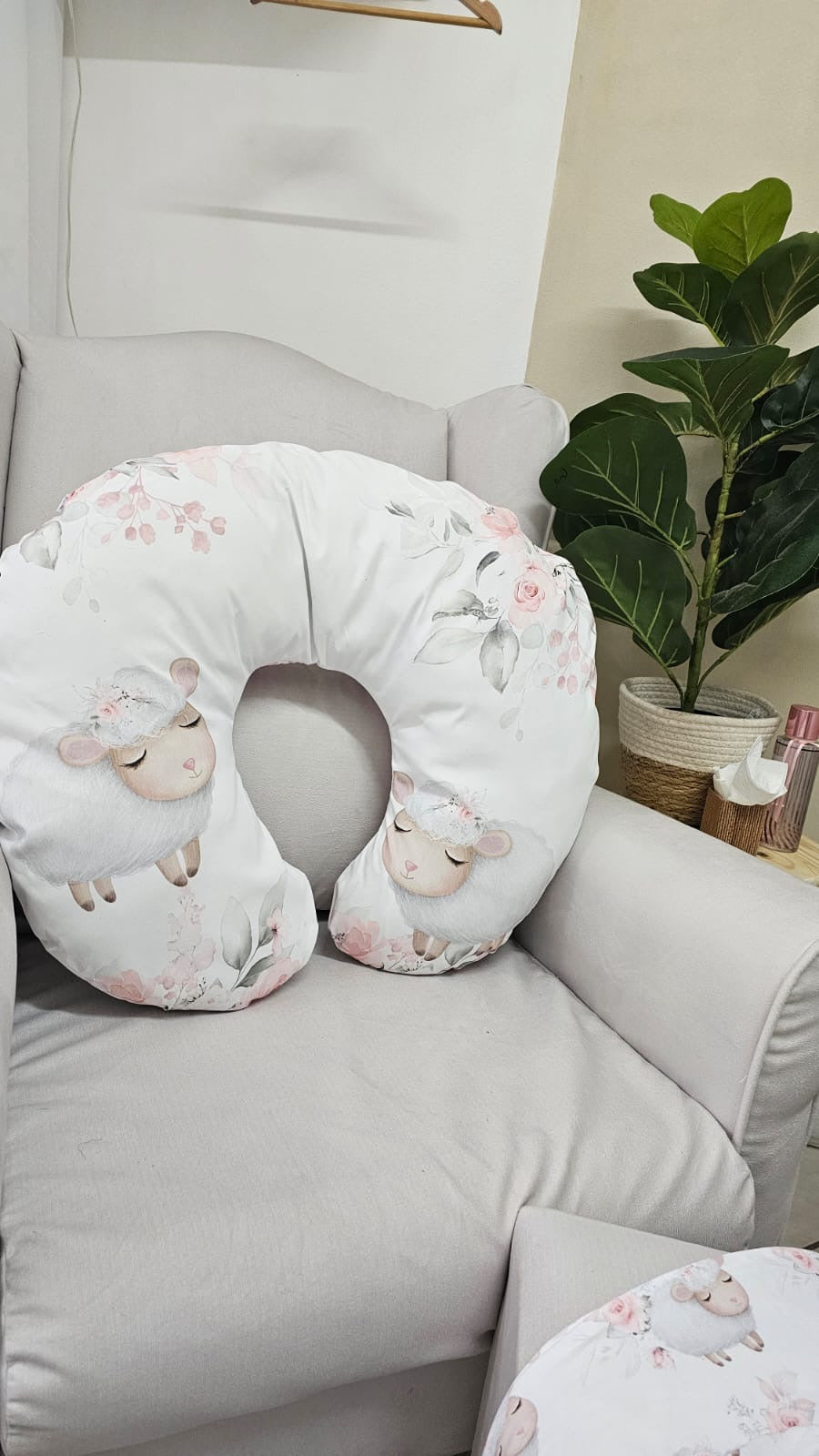 Boppy pillow with sheep design on a gray couch