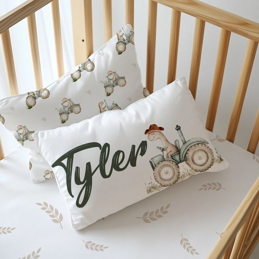 Dino Tractor Tails personalised nursery pillow featuring a sweet dinosaur riding a vintage-style tractor with the name “Tyler” in dark green script | Dino Tractor Tails gepersonaliseerde kinderkamer-kussing met ’n oulike dinosourus wat op ’n klassieke trekker ry, met die naam “Tyler” in donkergroen skrif.