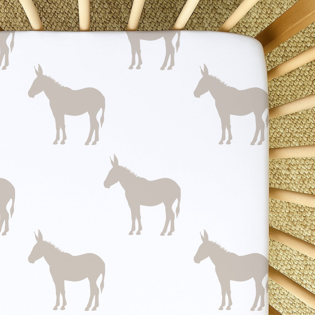 Donkey Dreams fitted cot sheet featuring a soft neutral donkey silhouette pattern in beige and cream, designed for a calm farm-themed nursery | Donkey Dreams bababed-laken met ’n sagte neutrale donkiesilhoeët-patroon in beige en roomkleurige skakerings, ontwerp vir ’n rustige plaas-tema babakamer.