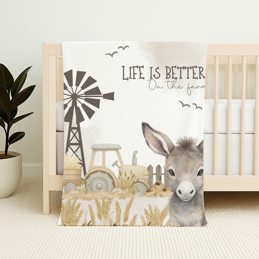 Donkey Dreams fleece blanket featuring a sweet donkey, tractor, windmill and soft neutral farm scene with the words “Life is better on the farm” | Donkey Dreams fleece-kombers met ’n oulike donkie, trekker, windpomp en sagte neutrale plaastoneel met die woorde “Life is better on the farm”.