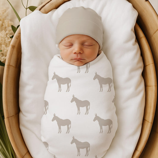Donkey Dreams baby swaddle set featuring a soft neutral donkey print in grey and cream tones, styled in a cosy newborn nursery | Donkey Dreams baba-inbakerstel met ’n sagte neutrale donkiepatroon in grys en roomkleurige skakerings, gestileer in ’n knus pasgebore babakamer.