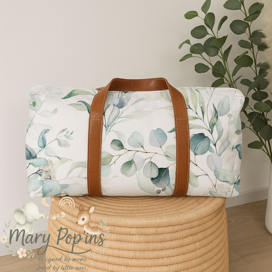 Eucalyptus hospital bag featuring a soft sage, eucalyptus and leafy botanical print on a white background with brown handles in a calm neutral style | Eucalyptus hospitaaltas met ’n sagte saliegroen, eucalyptus- en blaarbotaniese patroon op ’n wit agtergrond met bruin handvatsels in ’n rustige neutrale 