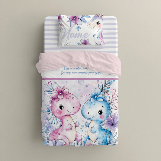 Girl Dino big bedding set featuring sweet pink and blue dinosaurs with floral details, soft pastel flowers and a gentle nursery design in pink, lilac and blue tones | Girl Dino groot beddegoedstel met oulike pienk en blou dinosourusse met blomdetail, sagte pastelblomme en ’n sagte kinderkamer-ontwerp in pienk, lila en blou kleure.