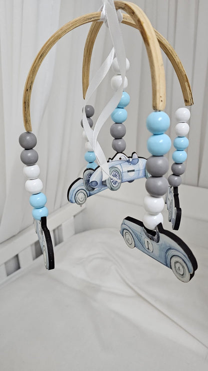 Baby mobile with cars and beads on a crib
