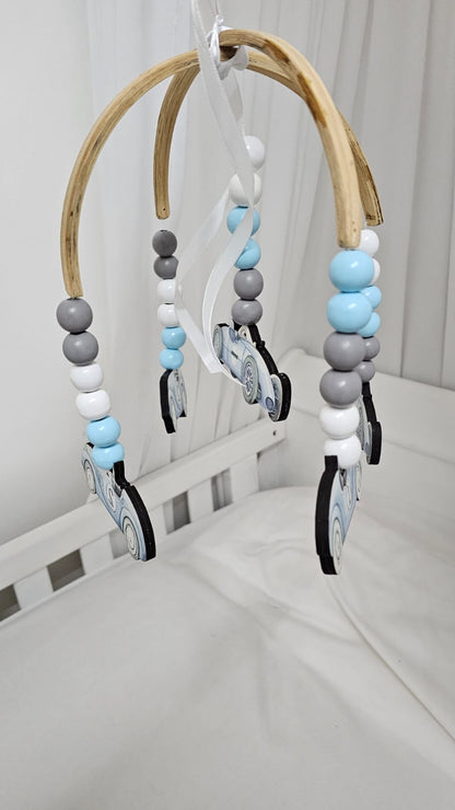 Baby crib mobile with beads and toys hanging from a wooden arch