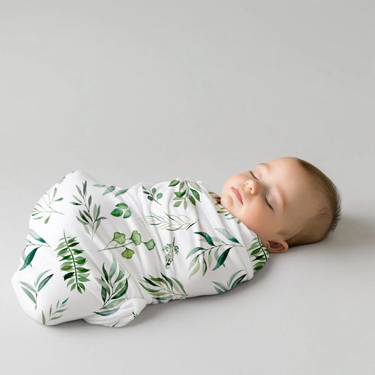 Leafy baby swaddle set featuring a fresh botanical print of soft green leaves and foliage on a clean white background | Leafy baba-inbakerstel met ’n vars botaniese patroon van sagte groen blare en loof op ’n skoon wit agtergrond.