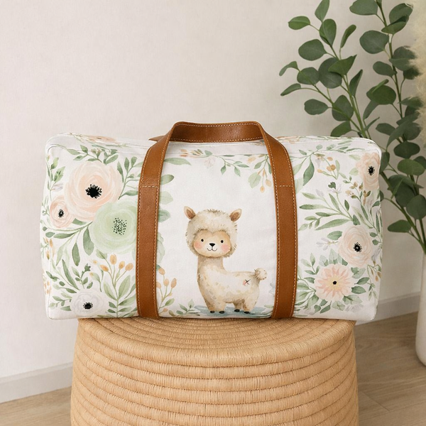 Llama Blossom hospital bag featuring a sweet llama surrounded by soft blush, cream and sage florals, finished with tan handles | Llama Blossom hospitaaltas met ’n oulike lama omring deur sagte ligpienk, roomkleurige en saliegroen blomme, afgewerk met bruin handvatsels.
