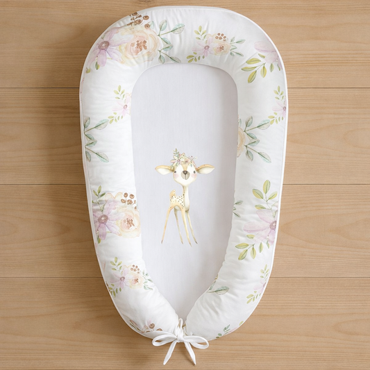 Lush Lavender baby nest featuring a delicate fawn design with blush and lavender florals, photographed flat lay on wooden surface