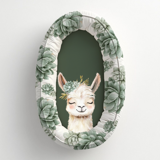 Neutral Succulents Llama baby nest featuring a sweet smiling llama with a soft sage succulent crown, surrounded by sage green succulent prints and a deep olive green centre | Neutrale Vetplante Lama babanes met ’n oulike glimlaggende lama met ’n sagte saliegroen vetplantkroon, omring deur saliegroen vetplant-afdrukke en ’n diep olyfgroen middel.