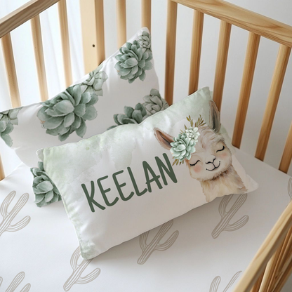 Neutral Succulents Llama personalised nursery pillow featuring a sweet smiling llama with a soft sage succulent crown and the name “Keelan” in dark green lettering | Neutrale Vetplante Lama gepersonaliseerde kinderkamer-kussing met ’n oulike glimlaggende lama, ’n sagte saliegroen vetplantkroon en die naam “Keelan” in donkergroen letters.