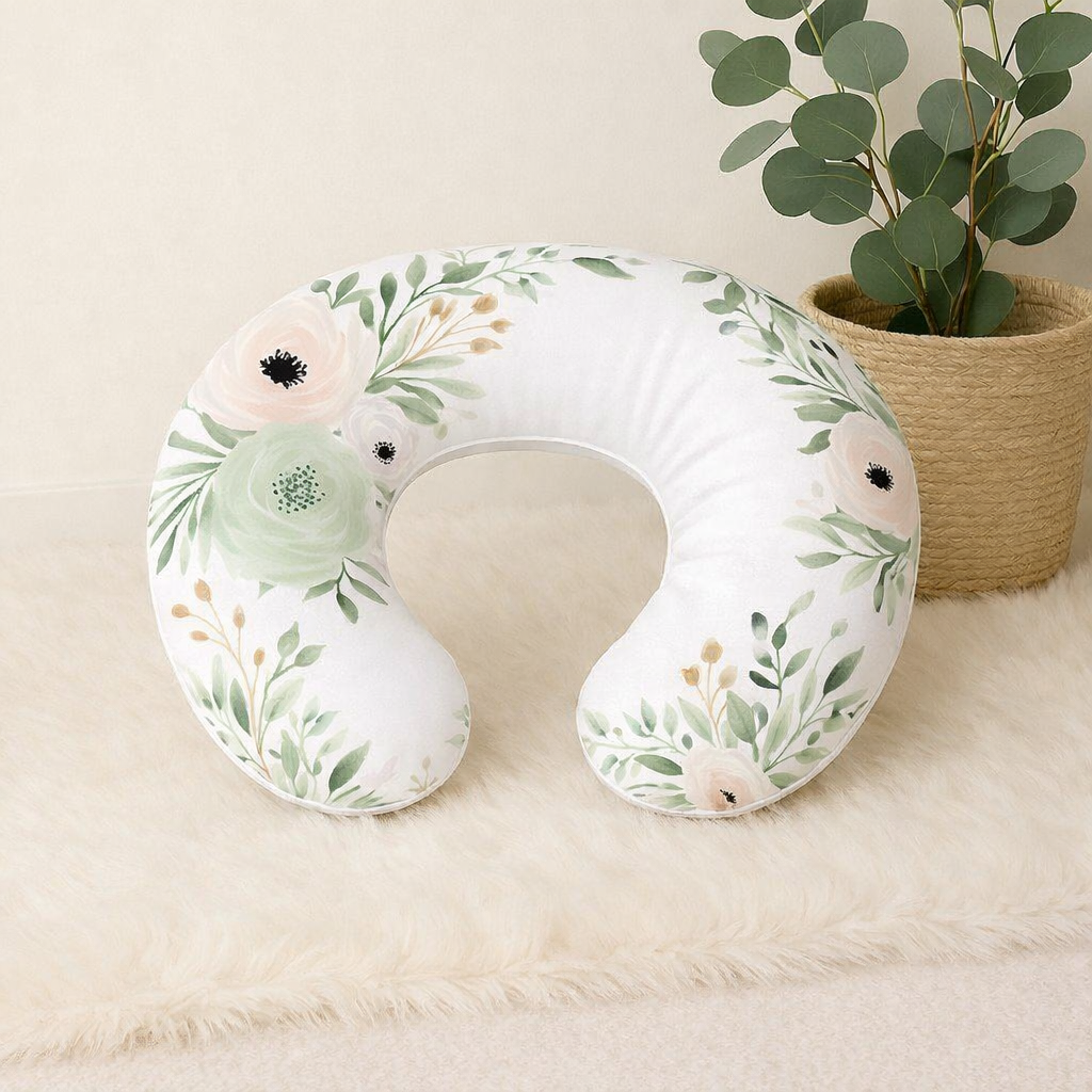 Peachy Blossom nursing pillow with soft blush and sage floral print on a white background, designed for comfortable baby feeding and support | Peachy Blossom voedingskussing met ’n sagte ligpienk en saliegroen blomdruk op ’n wit agtergrond, ontwerp vir gemaklike babavoeding en ondersteuning.