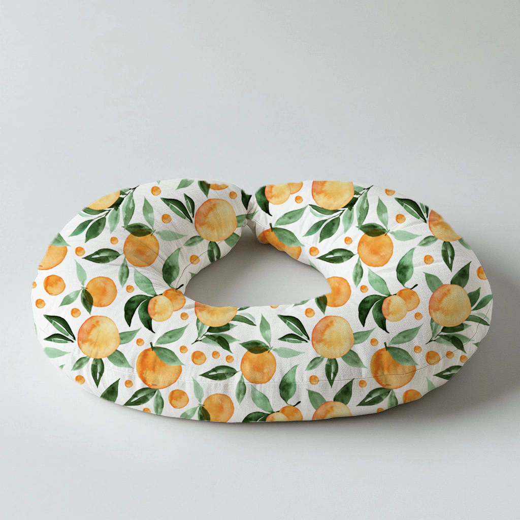 Peachy Goose nursing pillow featuring a fresh peach and green leaf print on a white background, designed for comfortable baby feeding and support | Peachy Goose voedingskussing met ’n vars perske- en groen blaarpatroon op ’n wit agtergrond, ontwerp vir gemaklike babavoeding en ondersteuning.