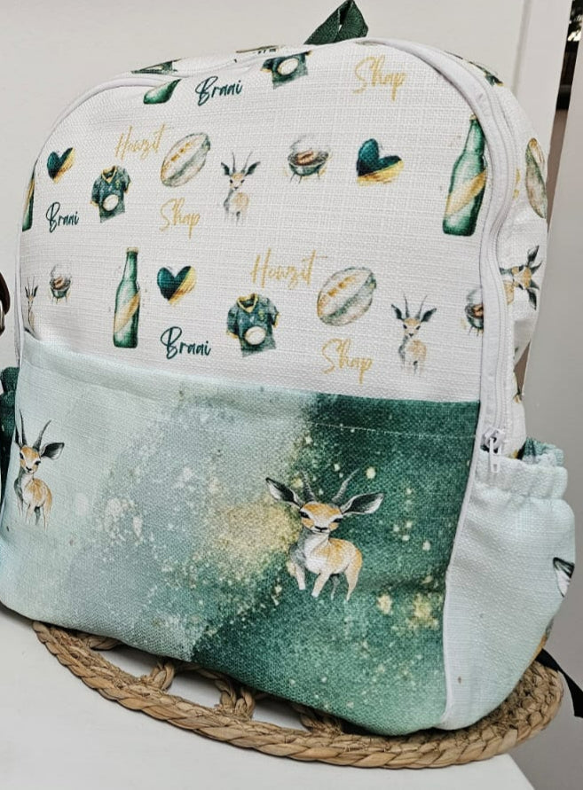 Springbok hospital backpack featuring a green and white South African springbok design with woodland-style antelope illustrations and practical storage pockets | Springbok hospitaalrugsak met ’n groen-en-wit Suid-Afrikaanse springbokontwerp, bokillustrasies en praktiese bêresakke.