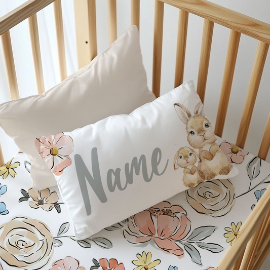 Subtle Blooms personalised nursery pillow featuring a sweet parent and baby bunny design with soft blush, cream, yellow and blue floral details and space for a personalised name | Subtiele Blomme gepersonaliseerde kinderkamer-kussing met ’n oulike ouer- en babahasie-ontwerp, sagte ligpienk, room, geel en blou blomdetail en plek vir ’n gepersonaliseerde naam.