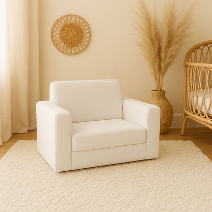 Soft white toddler couch with wide armrests and a cushioned seat, styled in a neutral nursery or children’s room | Sagte wit kleuterbank met breë armleunings en ’n gemaklike kussingsitplek, gestileer in ’n neutrale baba- of kinderkamer.