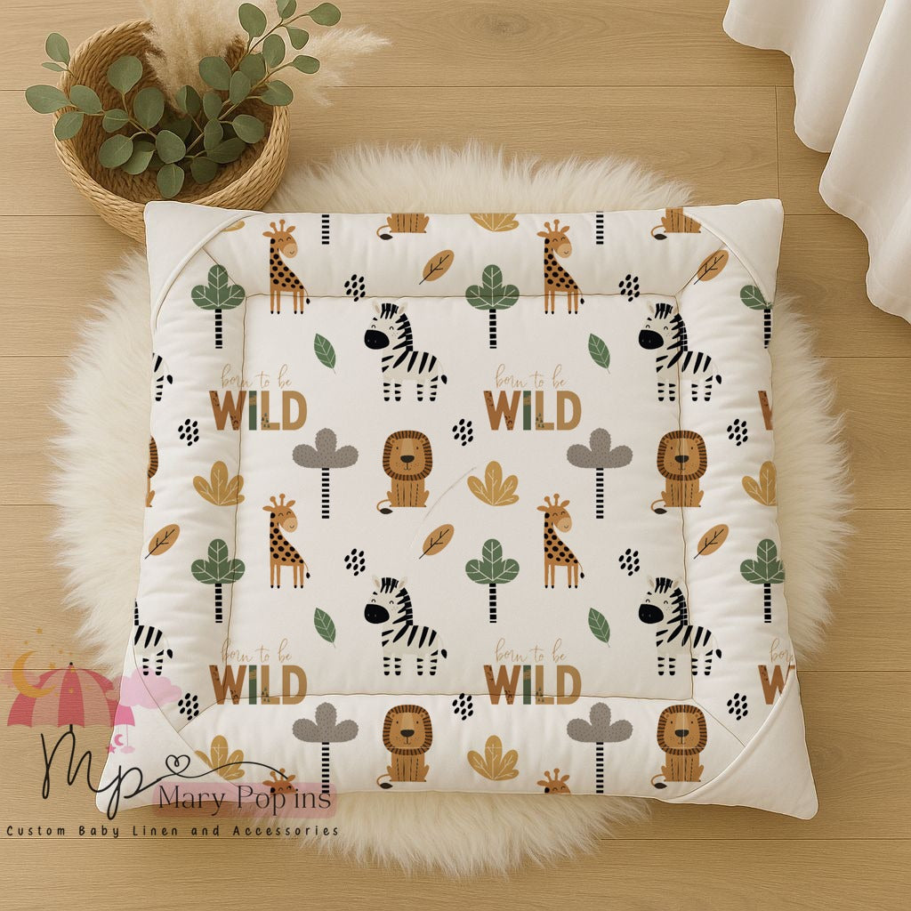 Wild Safari baby playmat featuring playful giraffes, zebras and lions with trees, leaves and “Born to be Wild” details in warm earthy tones | Wild Safari baba-speelmat met speelse kameelperde, sebras en leeus met bome, blare en “Born to be Wild”-detail in warm aardse kleure.